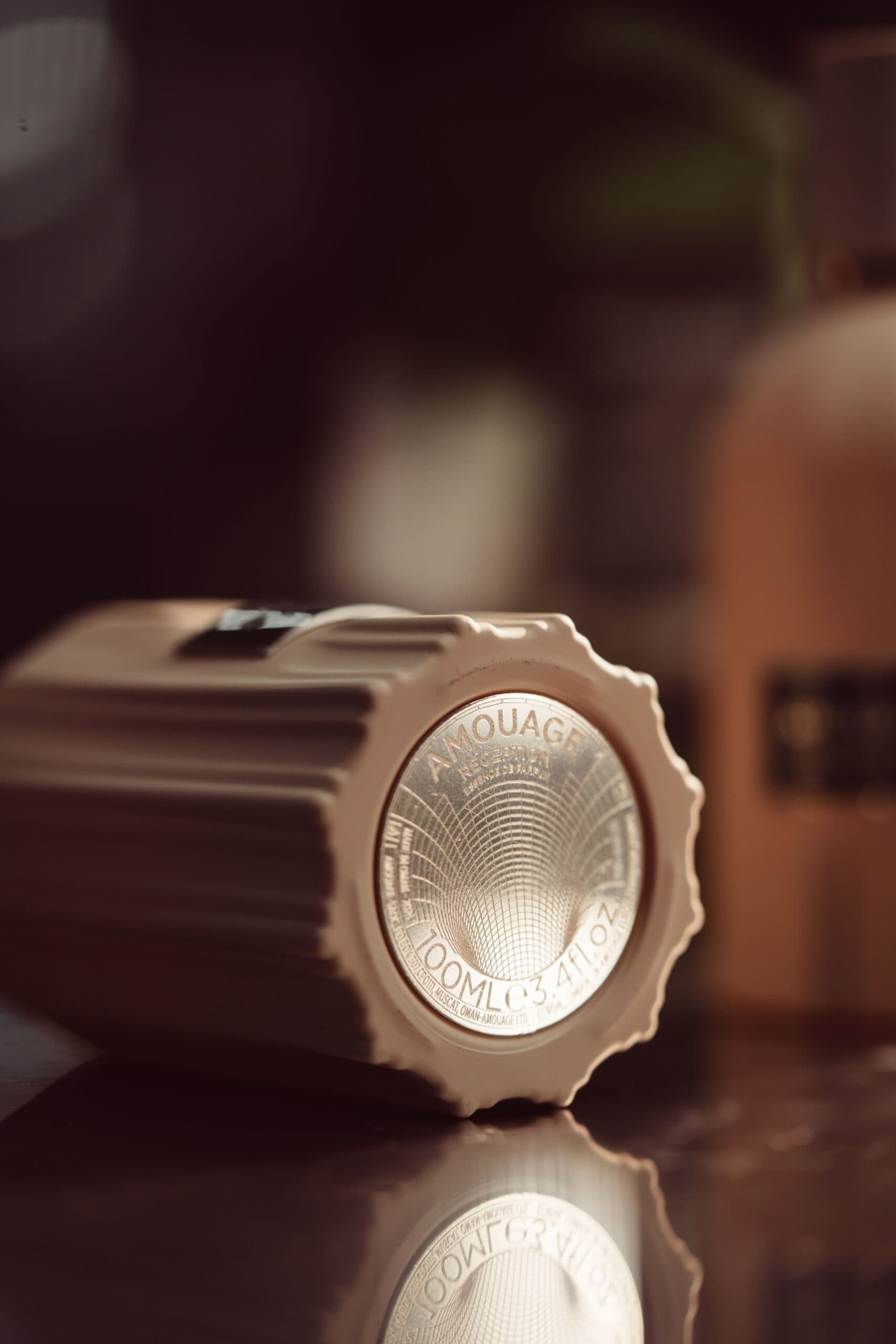 Amouage Reception fragrance inspired by coffee, lemon, pine, pink pepper, frankincense, patchouli, cedarwood, vanilla, cypriol, and musk, evoking the warmth and depth of connection