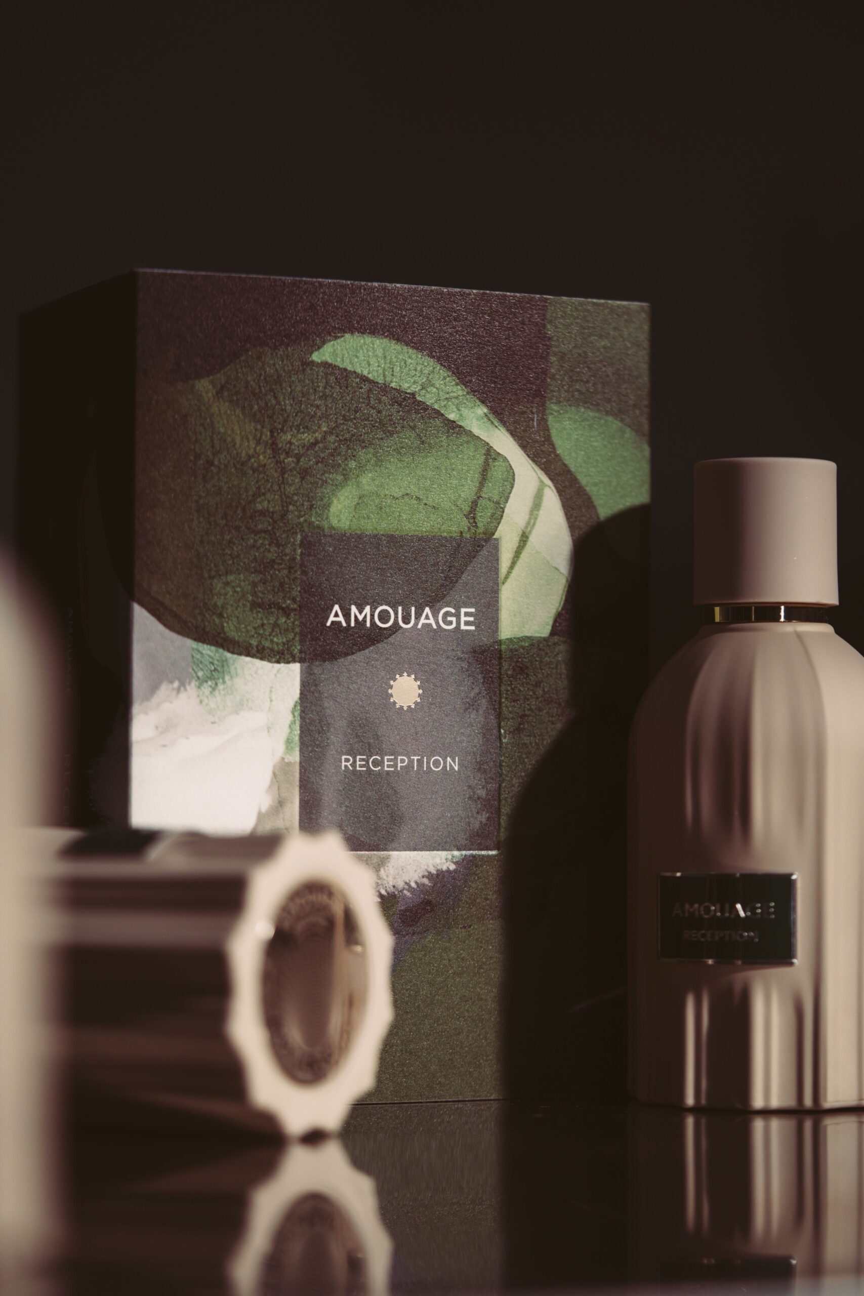 Amouage Reception fragrance inspired by coffee, lemon, pine, pink pepper, frankincense, patchouli, cedarwood, vanilla, cypriol, and musk, evoking the warmth and depth of connection